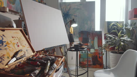 Creative-Art-Studio-with-Easel,-Paintings-and-Tools