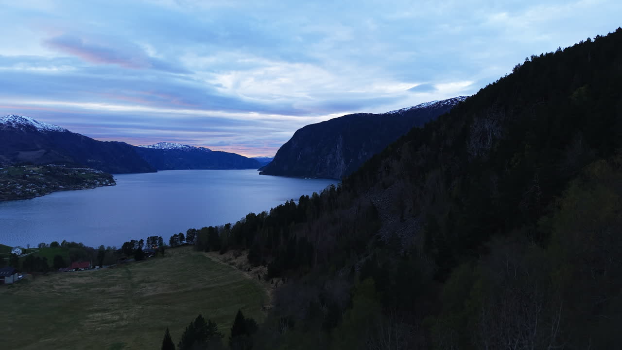 Pemandangan Menawan Lembah Norwegia Saat Senja, dengan Puncak Bersalju di Kejauhan. Ideal untuk Promosi Perjalanan atau Film Dokumenter Pemandangan