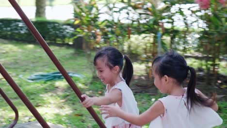 active little sisters are running in the outdoor playground in the park. happy child girls smiling and laughing on children playground. the concept of play is learning in childhood.