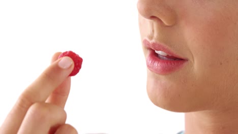 Close-up of woman having raspberries