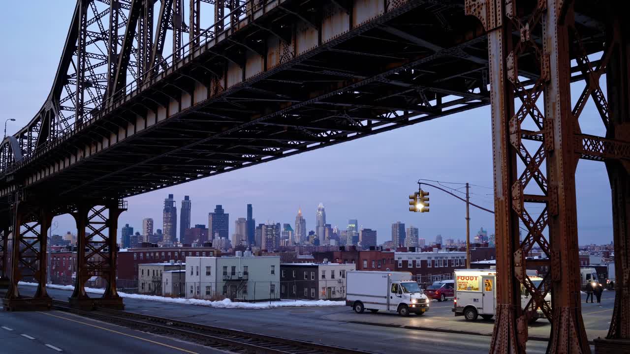 Urban video scene with a low-angle view of a bridge framing a city skyline at dusk