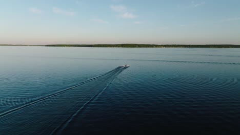 Disparo-De-Drones-Siguiendo-Una-Moto-De-Agua-En-Un-Gran-Lago-Al-Atardecer