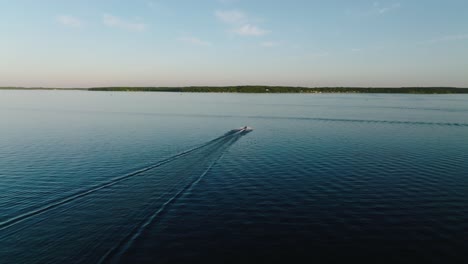 disparo de drones siguiendo una moto de agua en un gran lago al atardecer