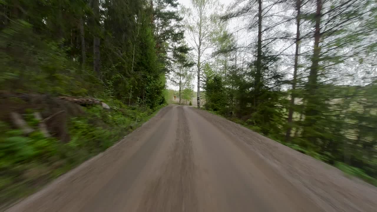 La strada attraversa vasti campi, con alberi sparsi lungo il suo percorso