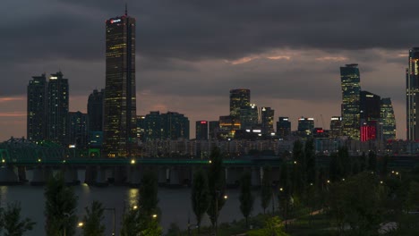 seoul at night - 63 building skyscraper with han river railway bridge in foreground in seoul, south korea