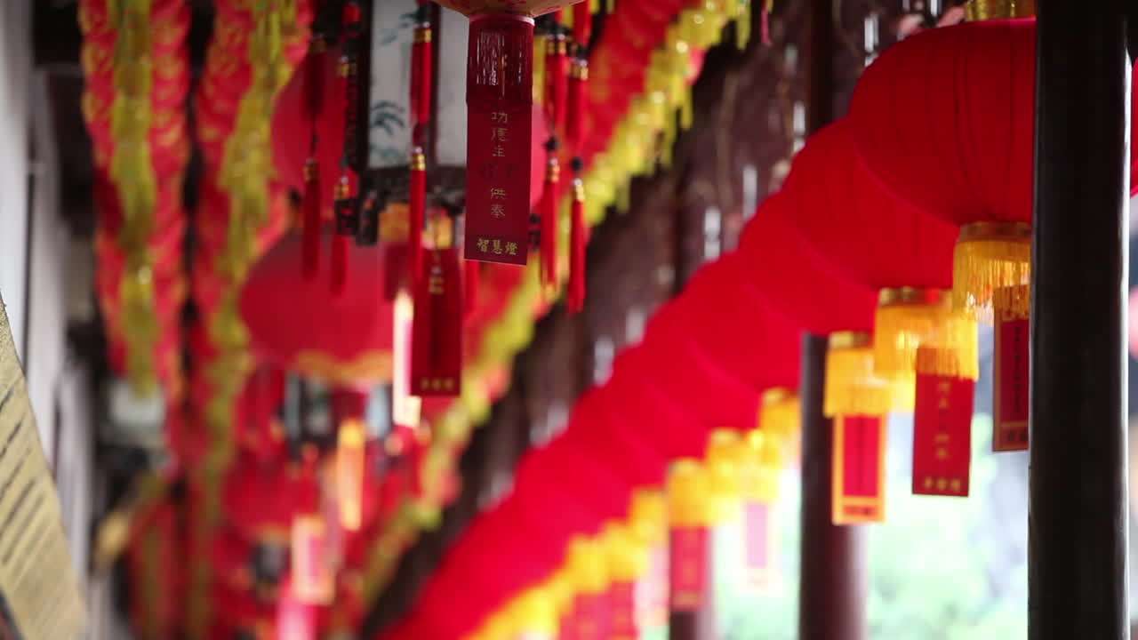 Farolillos y borlas cuelgan de las vigas en un templo budista en China