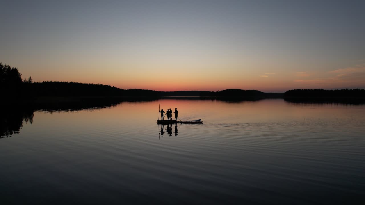 Gruppe af mennesker padler i solnedgangen på Saimaa-søen