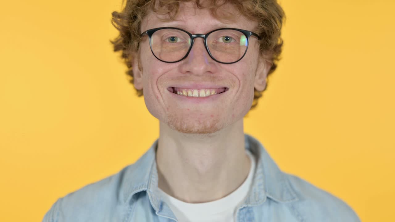 Close Up of Smiling Redhead Young Man on Yellow Background