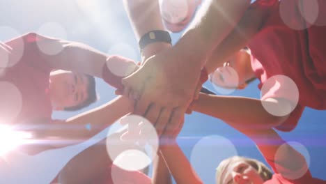 Animation of light spots over diverse schoolchildren teaming up with coach at stadium