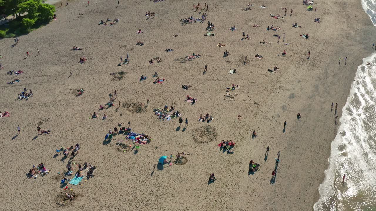 Aerial ascending view of crowded beach after city restrictions ease from the COVID-19 pandemic