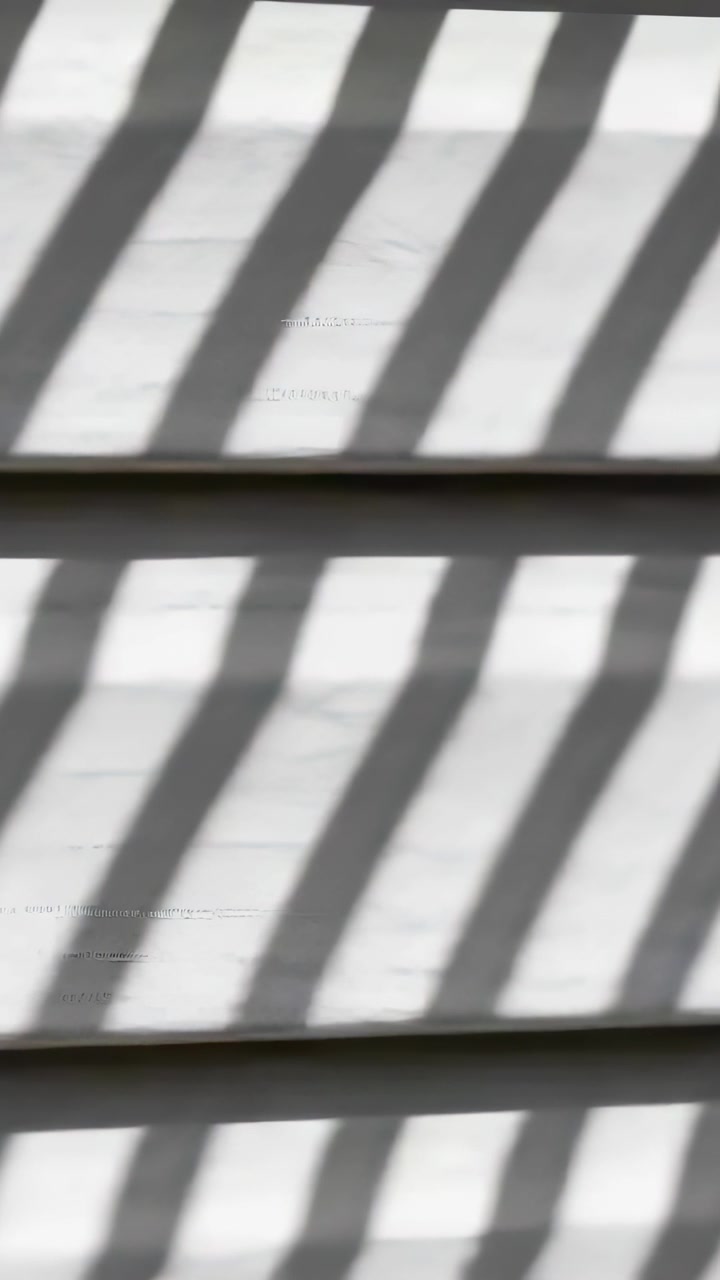 Vertical video: Casting railing shadows, sun shifting light across clapboard siding with trim seams