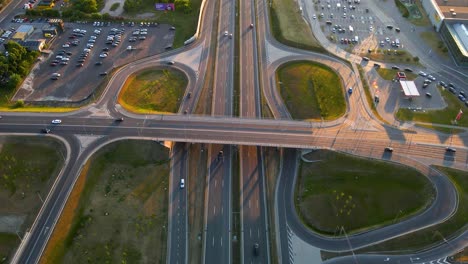 aerial of the traffic on the highway and the interchange with buildings in the background