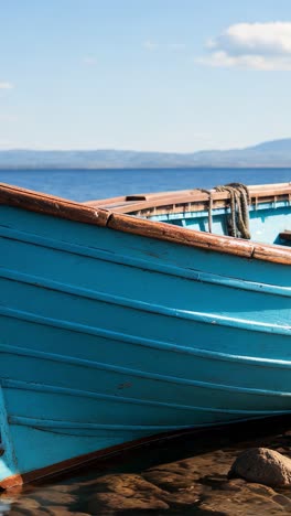 bright blue wooden boat floating on calm water under clear skies