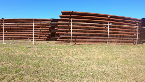 pov driving past a large stockpile of panels for building the border wall between texas and mexico