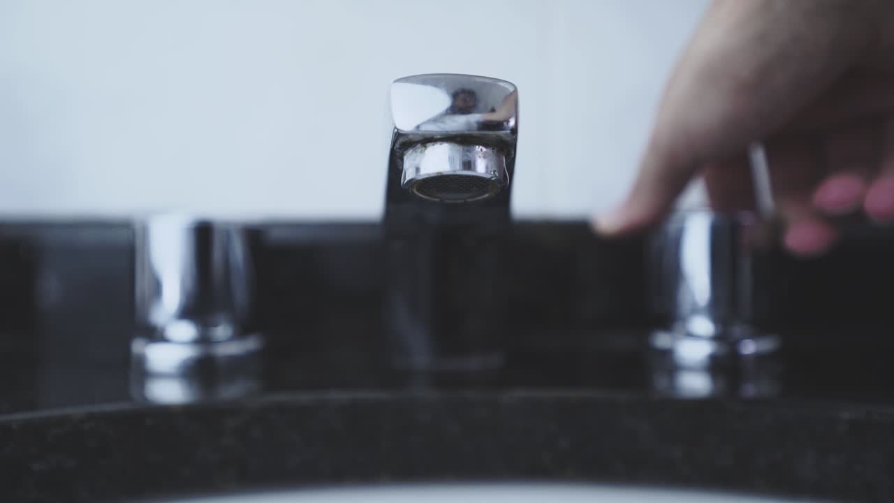 Closing an open bathroom faucet in slow motion