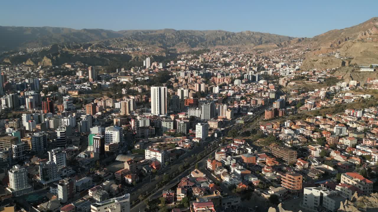 vista panorámica de los edificios a lo largo de la carretera en la paz, bolivia con montañas en el fondo en un día soleado