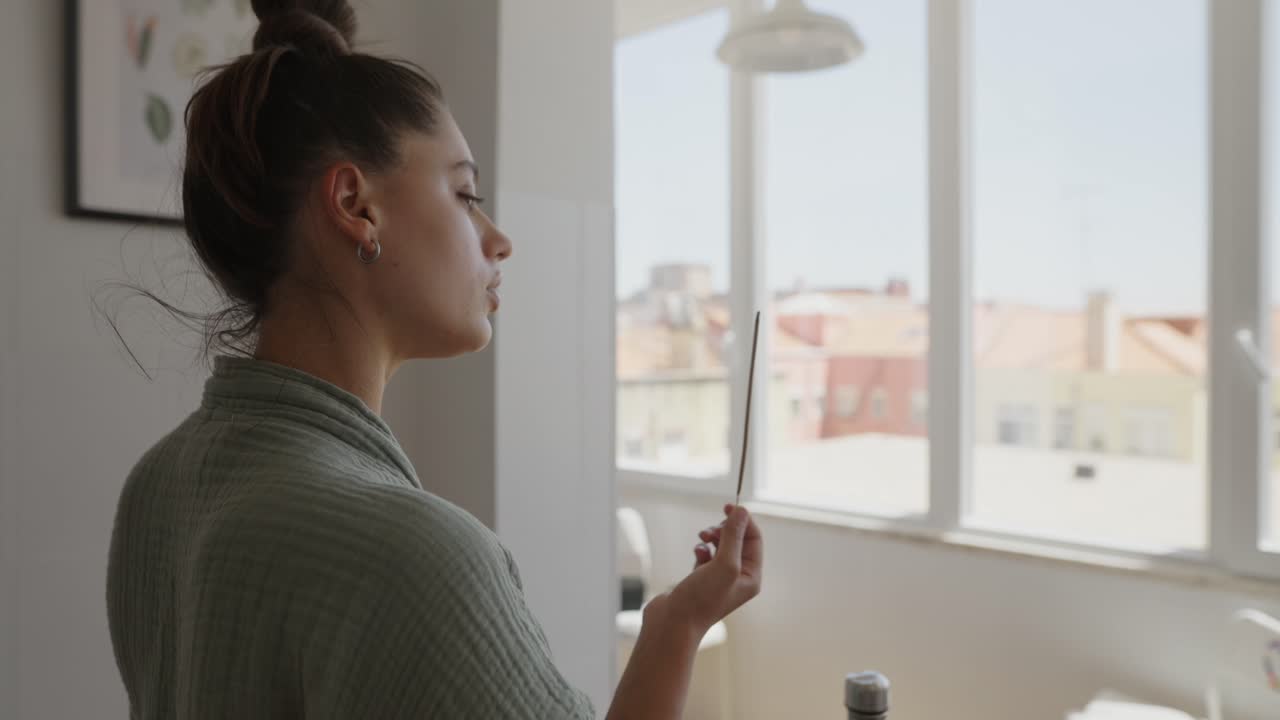A woman with an incense stick indoors