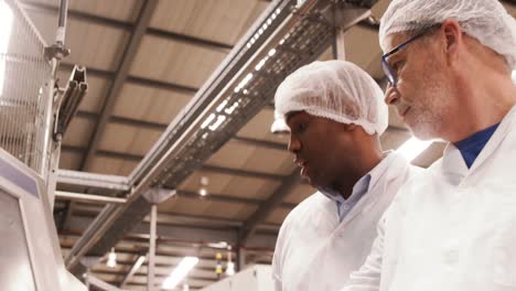 trabajadores examinando una máquina en la fábrica