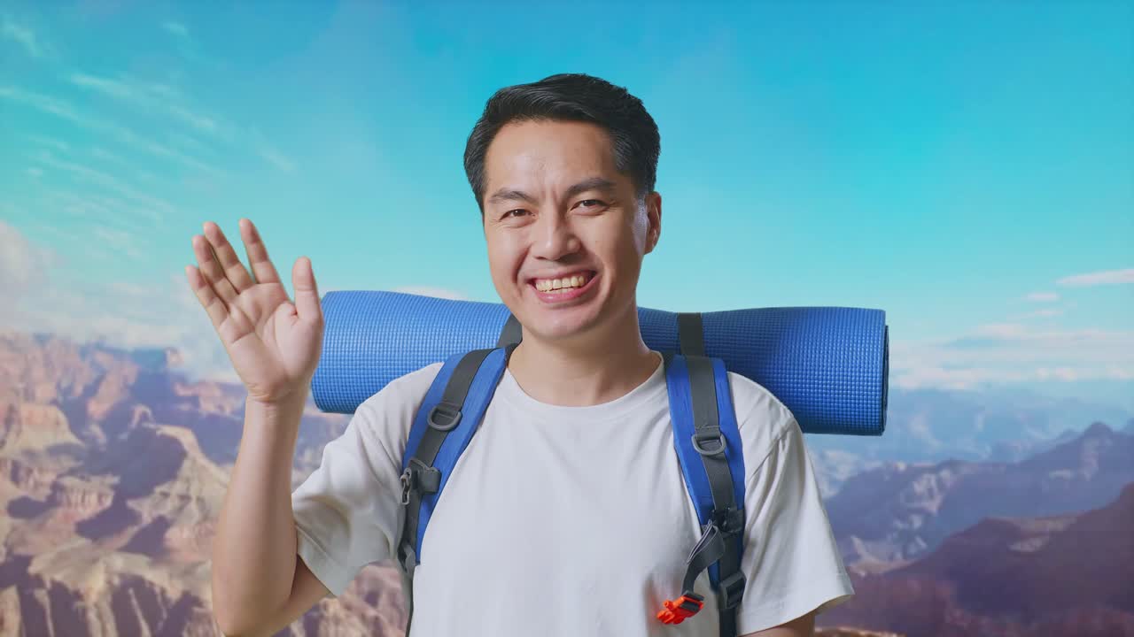 Close Up Of Asian Male Hiker With Mountaineering Backpack Waving Hand And Saying Bye While Traveling At The Top Of Mountain