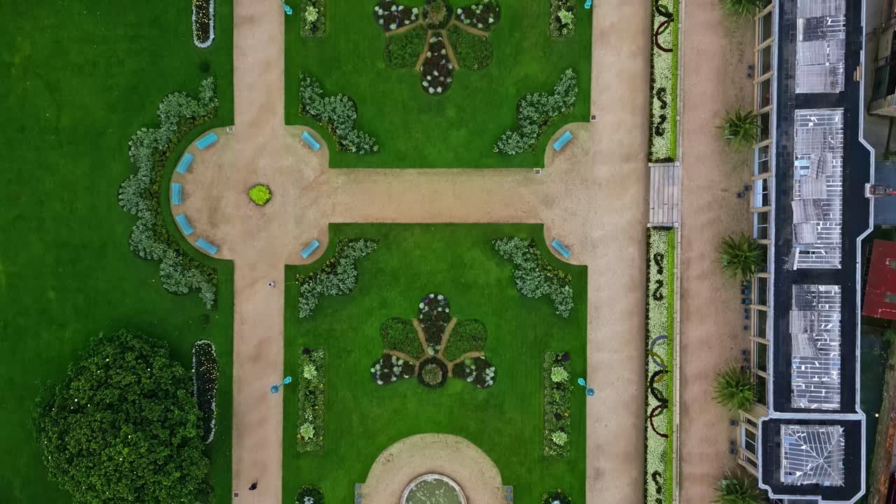 Drone flying over Thabor gardens with fountains and flower beds, Rennes in France. Aerial drone top-down forward