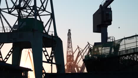 Silhouettes-of-big-cranes-in-Gdańsk,-Poland