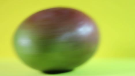 close-up of spinning mango fruit on a yellow background