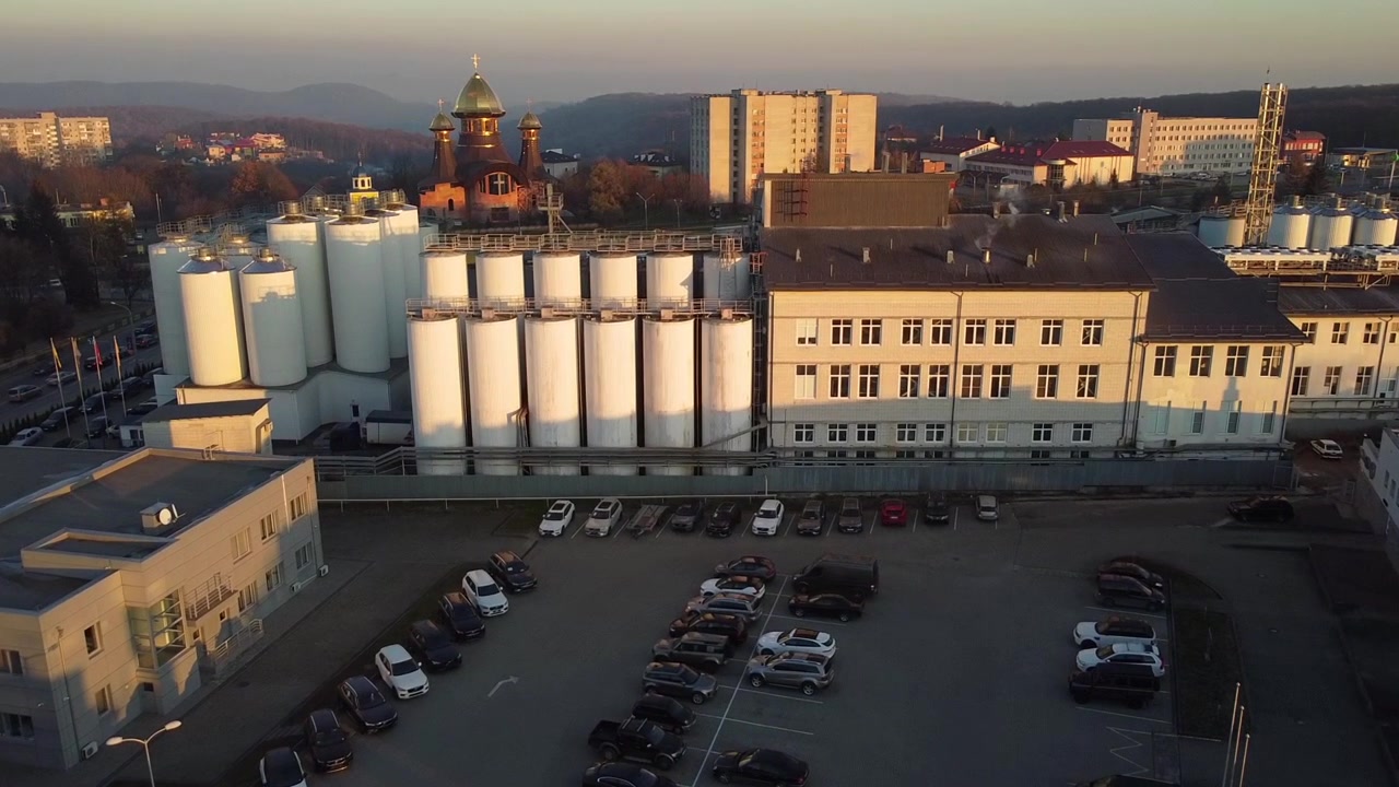 Vista aerea di un drone che sorvola il birrificio, diverse file di serbatoi
