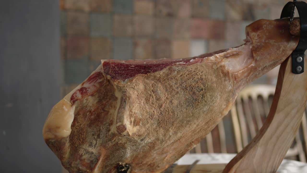 cured presunto ham leg on wooden holder ready for slicing indoors