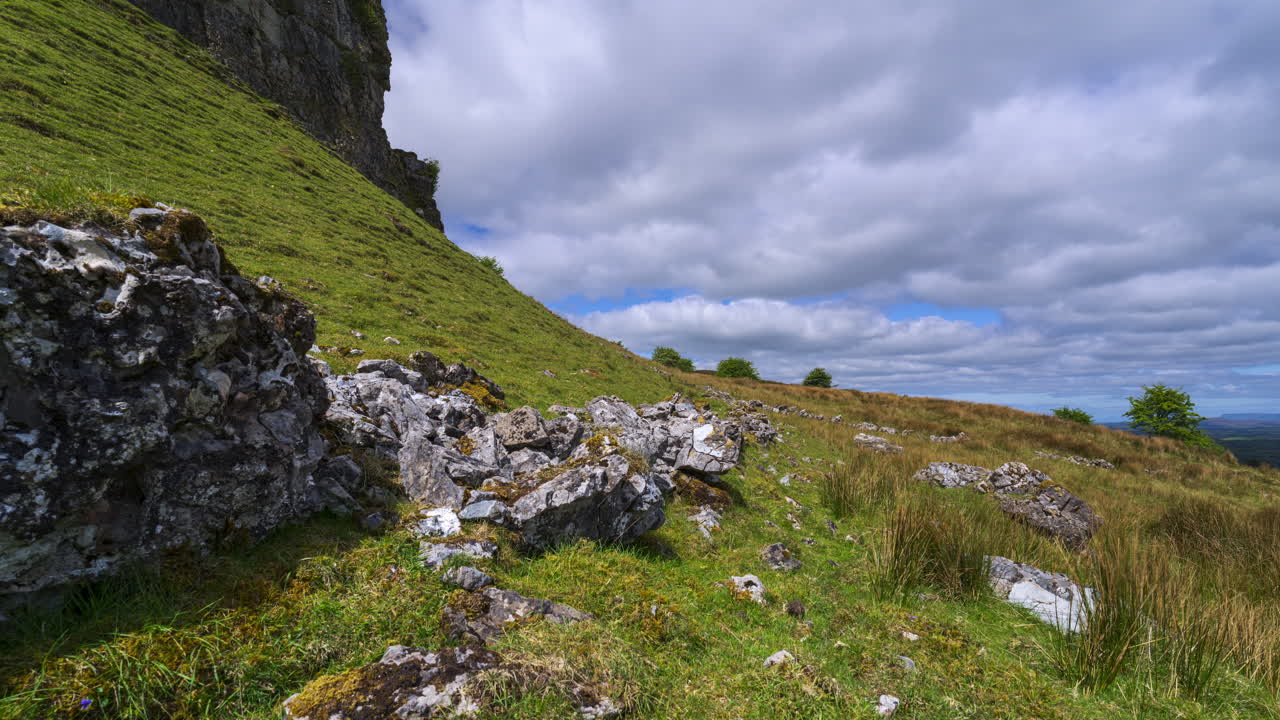 Timelapse av et landlig landskap med fjellformasjon i forgrunnen og åser i det fjerne på en solrik, skyet dag sett fra Carrowkeel i grevskapet Sligo i Irland