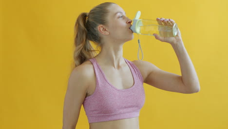 woman drinking water after exercise