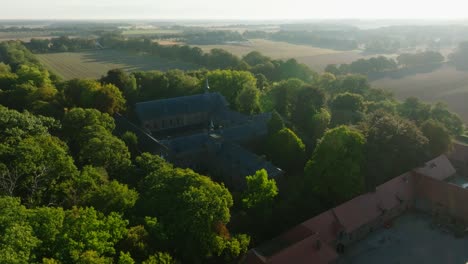 Drone-shot-of-a-beautiful-monastery-surrounded-by-green-tree's-in-the-nature-of-a-country