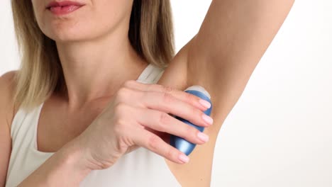 woman applying deodorant to her armpit