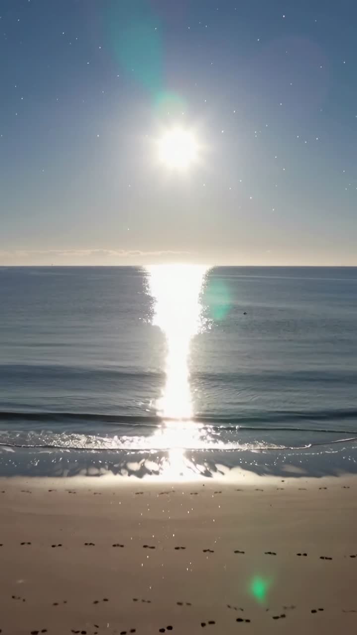 Sole splendente che si riflette sulle onde calme dell'oceano in spiaggia