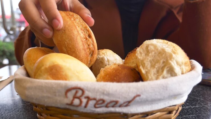 Hand picking bread from a basket