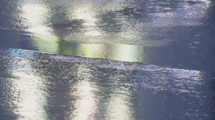 Person In Sneaker Shoes Walking On Wet Asphalt Road With Reflections During Rainy Night