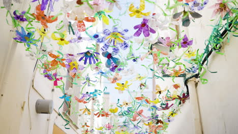 colorful recycled flower decorations in an alleyway
