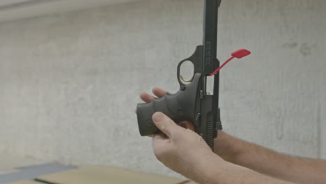 man safely showing a empty handgun with a chamber flag and clear magazine well