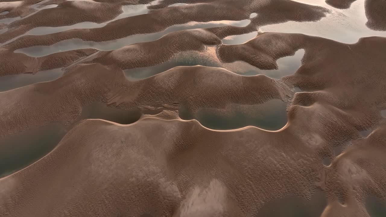 Intricate patterns of seawater pools and sand banks catching the low angled light at sunset.