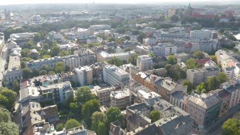 Aerial-drone-backward-moving-shot-overurban-city-of-Krakow,-Cracow-in-Poland-with-heavy-traffic-movement-at-daytime