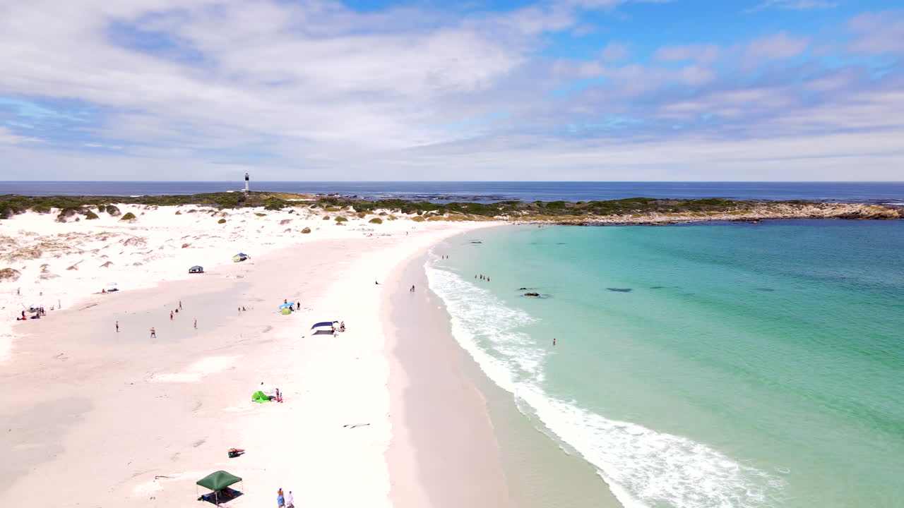 Bathers enjoy summer's day at Moonlight beach with perfect clear water, aerial