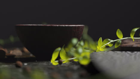 Primer-Plano-De-Una-Ramita-De-Albahaca-Fresca-Y-Un-Cuenco-De-Madera-Sobre-Una-Mesa-De-Madera-Vieja.-Hoja-De-Cuchillo-Apuntando-Hacia-La-Cámara.-Fondo-Perfecto-Para-Cocina,-Cocinar,-Gourmet,-Culinario,-Hierbas,-Diseño-Rústico.