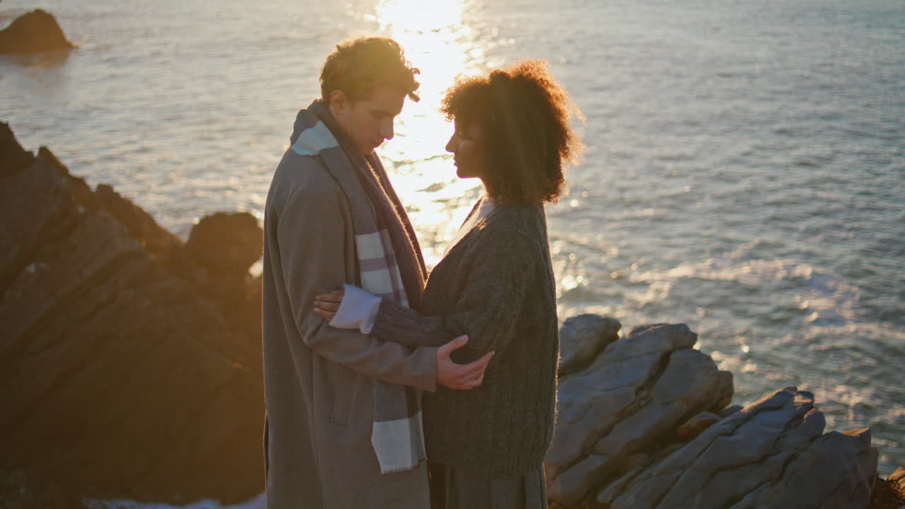 Affectionate lovers embracing sunrise at coast closeup. Enamoured pair hugging