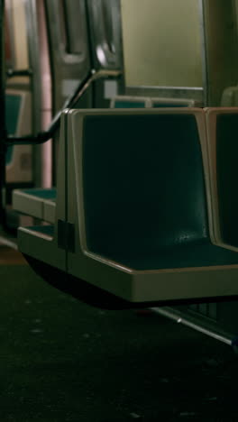 empty subway car with blue seats and a yellow light