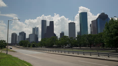 houston, texas road with downtown buildings looming large in silhouette in background