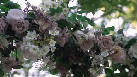 lush floral arrangement with pink and white roses and greenery in an outdoor setting