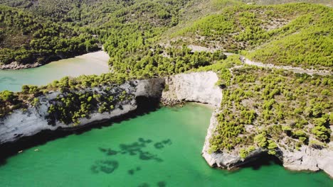 drone flying in circulair motion over the rugged coastline of gargano national park in italy in 4k