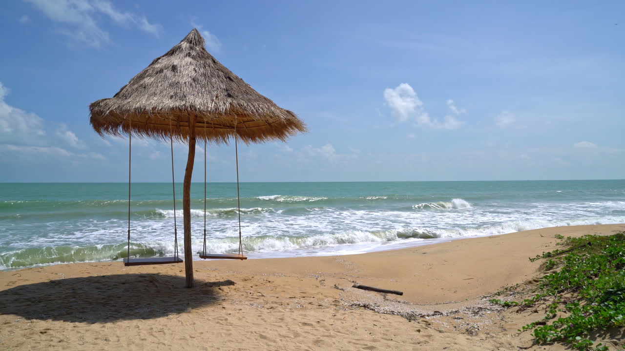 columpio en la playa con mar océano y fondo de cielo azul