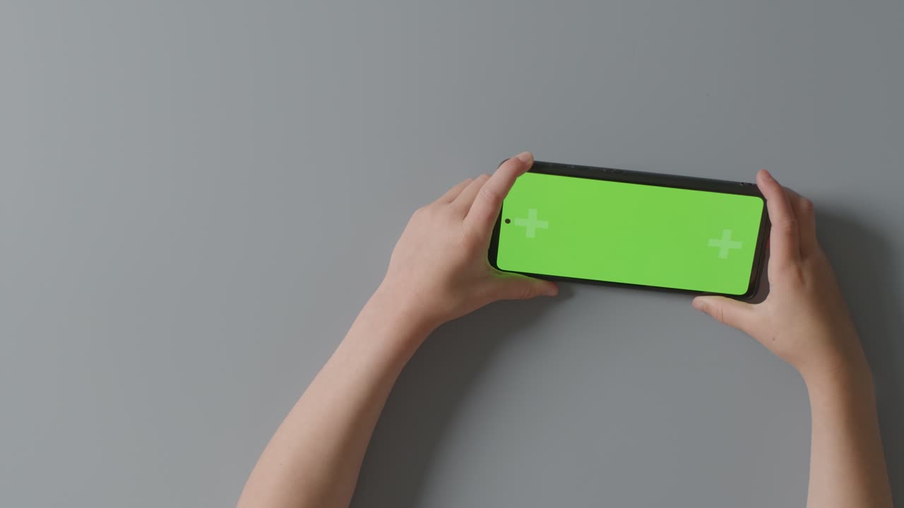 녹색 화면 디지털 태블릿을 수평으로 들고 콘텐츠를 시청하거나 스트리밍하는 어린이의 오버헤드  ⁇  1