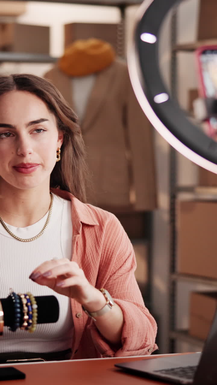 Giovane donna che fa vlogging su gioielli e braccialetti per un'attività online.