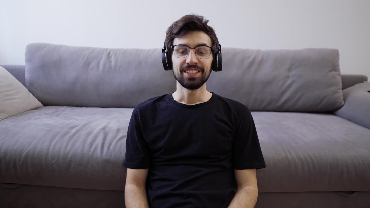 un alegre bloguero filmando un video para sus seguidores, espectadores en casa, saludando con la mano